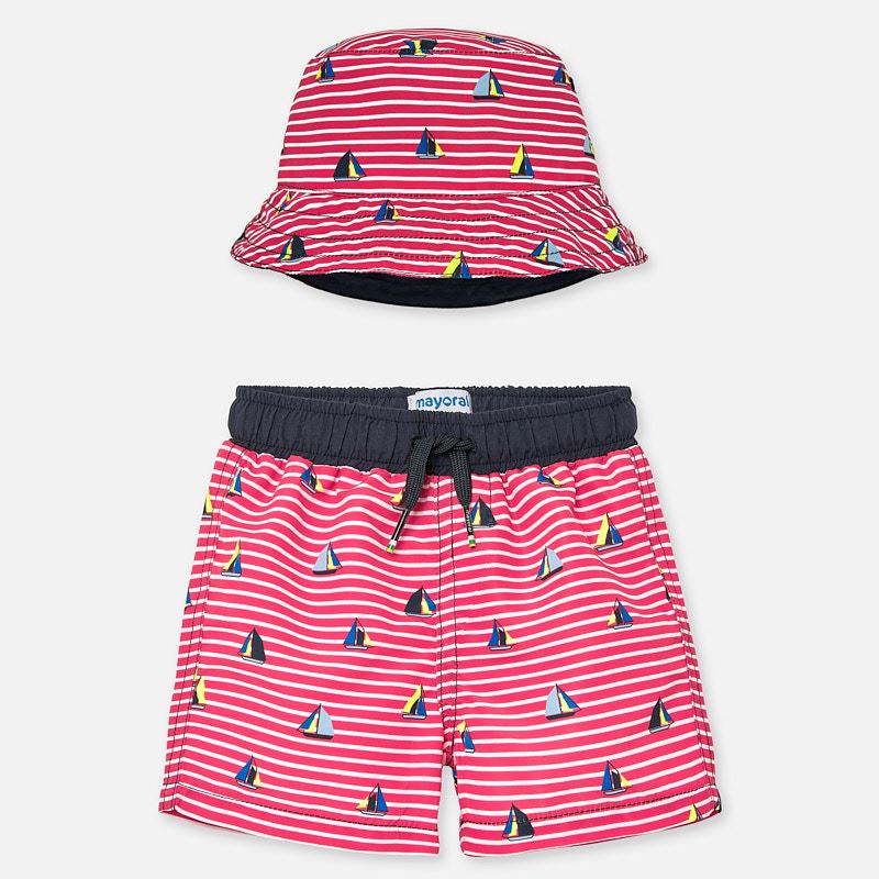 Mayoral Singapore Swimwear. Little boys swimming trunks and reversible sun hat by Mayoral, with red and white stripes and sailing boat print. Made from soft polyester, the trunks have a comfortable mesh lining, and the reversible hat has a navy blue side.